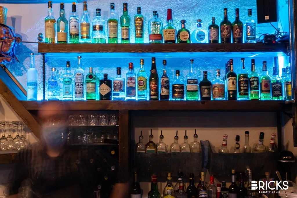 Spirits and whiskey shelves under blue lights